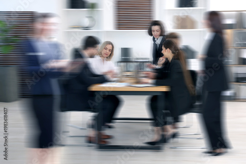 Obraz na plátně Colleagues working indoors, motion blur effect