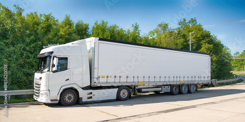 White semi truck with trailer parked on roadside, freight transport and logistics concept, commercial delivery vehicle for cargo shipping and trucking business. Copy-space.