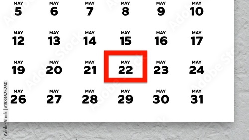 Close-up of the date May 22nd marked with a red cursor on the wall calendar 2026