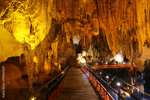 Red pathway underground cave in Laos with Illuminated stalagmites and stalactites