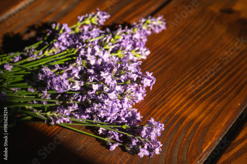 Macro shot of fresh purple lavender flowers bouquet on a rustic wooden table. Beautiful floral background for aromatherapy, spa, wellness and home decor concepts