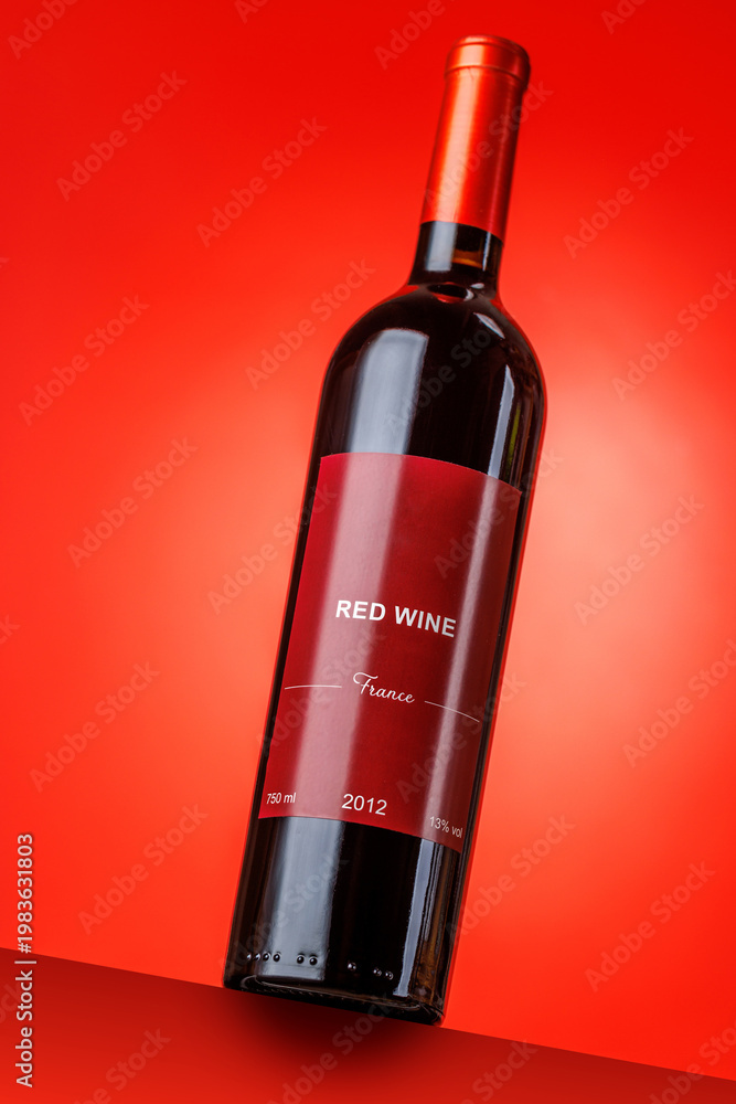 Fototapeta premium Red wine bottle mockup on red background