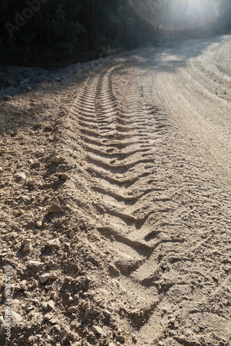 Tire tracks on sandy road in construction area, texture of heavy machinery traces in park development site