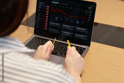 A person holds a broken pencil in both hands, symbolizing frustration, stress, or worry about financial losses or poor investment decisions. The setting appears to be a work desk, reinforcing the idea