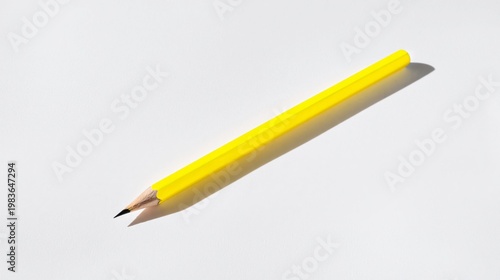 Yellow Pencil on a White Surface With Shadow Created by Natural Light