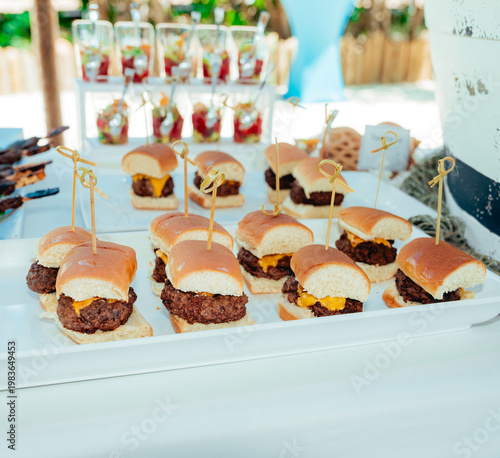 Mini cheeseburger sliders served on catering tray at outdoor event