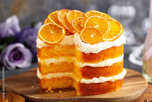 Orange Cake With Cream Layers and Dried Orange Slices on a Wooden Board
