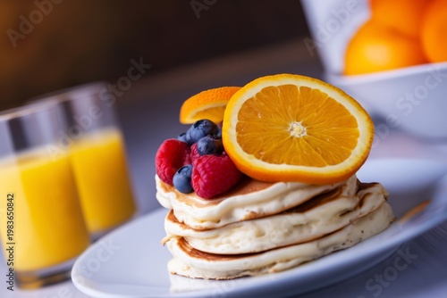 Pancakes With Fruits and Orange Juice on a White Plate During Breakfast Time