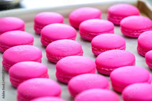 Bright Pink Macarons Arranged on a Baking Tray in a Kitchen for a Dessert Dis...