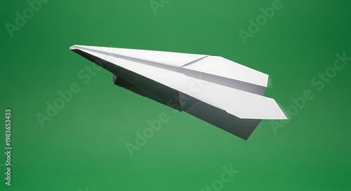 A classic white paper airplane mid-flight against a solid green background