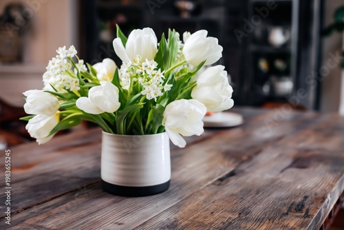 White Flowers in a Vase on a Wooden Table at a Cozy Indoor Setting During Day...