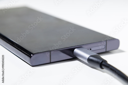 USB Type C cable plugged into smartphone for charging and data transfer