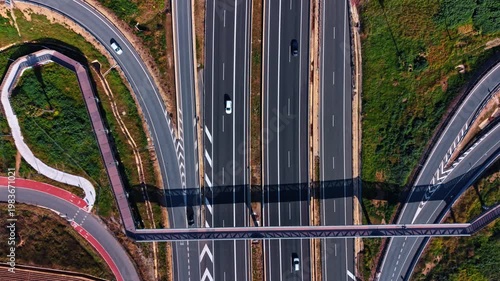 Flight over the modern parallel motorways. A footbridge and trestle are over the highways.