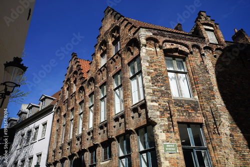 Schöner Altbau mit mit altem Mauerwerk aus Naturstein in Beige und Naturfarben mit Treppengiebel in den Gassen der Altstadt von Brügge in Westflandern in Belgien	