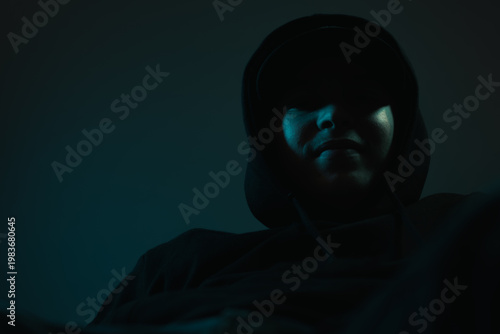 Low angle shot of a young smiling hip-hop artist in hoodie and cap