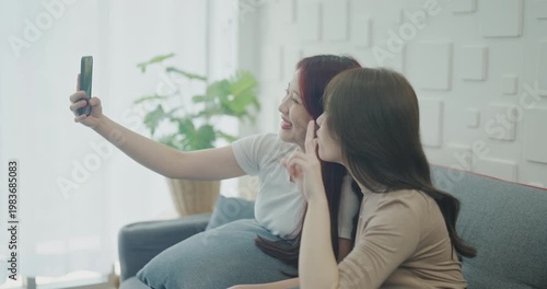 Wallpaper Mural Roommate concept of 4k Resolution. Asian women playing on mobile phones together in the living room. Torontodigital.ca