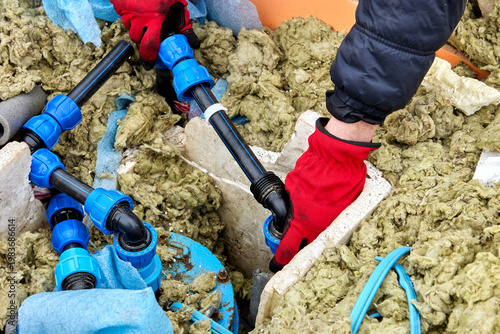 Compression fitting in hand of plumber repairing well pit.