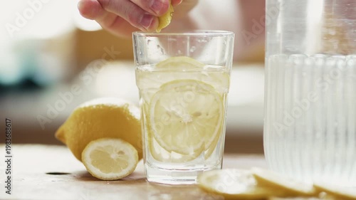Close Up of Man Squeezing Fresh Lemon Slice into Glass of Water 4K 10-bit