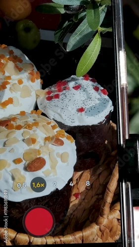 Italian Easter bread colomba pasquale arranged on table as female hands film soft paska and kulich on mobile phone for food blog with festive bakery details