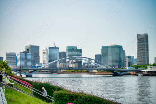 View of the bridge leading to Tsukiji Fish Market in Tokyo, showcasing bustling streets, urban architecture, and city activity
