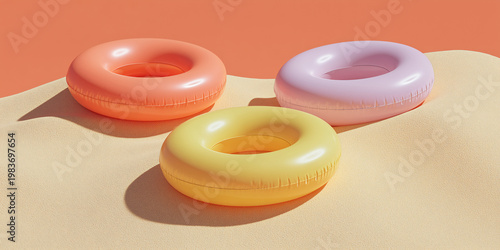 Three vibrant inflatable rings rest on a textured surface, evoking summer fun and relaxation