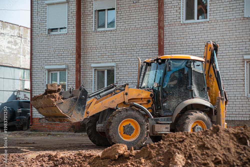 Obraz premium Excavator hooks pieces of concrete slabs to clear the construction site for foundation construction
