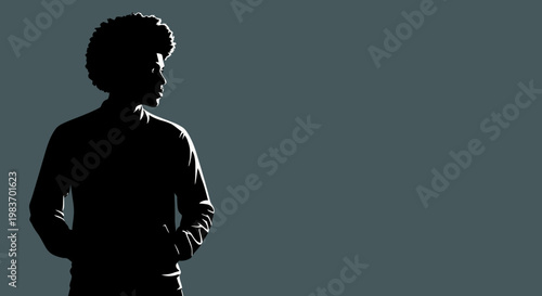 Silhouette of a young man with afro hairstyle looking thoughtfully into the distance