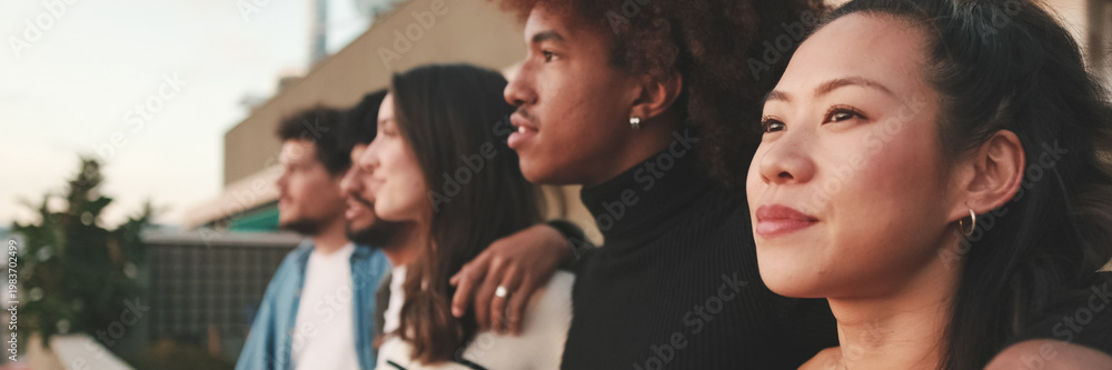 Obraz premium Close-up of young people, guys and girls friends standing hugging each other on the balcony looking at the beautiful views. Panoramic