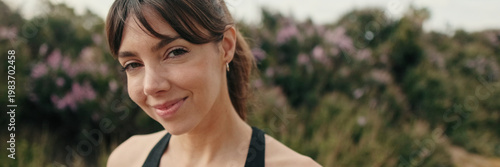 European smiled girl in sportswear against the park and trees, fit woman portrait looking at camera. Panoramic