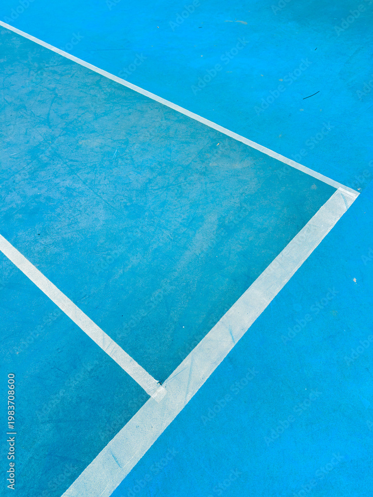 Obraz premium Lines of a court on a blue surface with clean edges showing a backdrop for a sports activity during the day in a recreational area