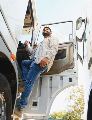 Cuadro en lienzo Indian truck driver smiling stepping into vehicle