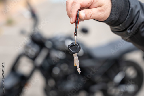 Fotografía Hand holding key to a motorcycle, concept of vehicle purchase, ownership, and ne