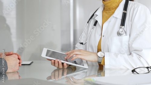 Tableau sur toile Doctor consulting patient using digital tablet, explaining medical information during modern healthcare appointment