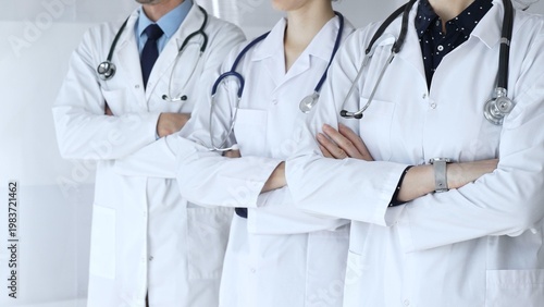Photos Medics from the team in white coats and with stethoscopes stand with their arms