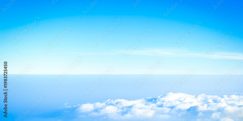 Obraz premium High angle view of clear blue sky with horizon and fluffy white clouds below.