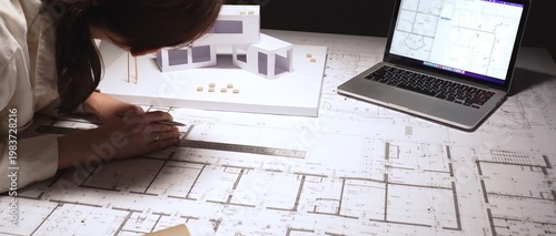 Billede på lærred Architect designing modern building using laptop for blueprints and drafting flo