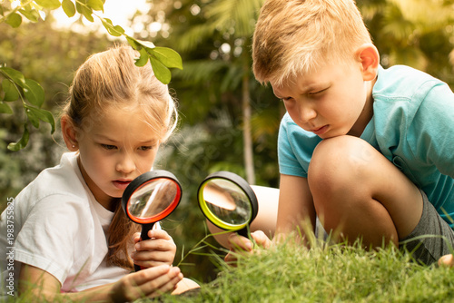 Children Exploring Nature Together with Magnifying Glass Outdoor Learning.
