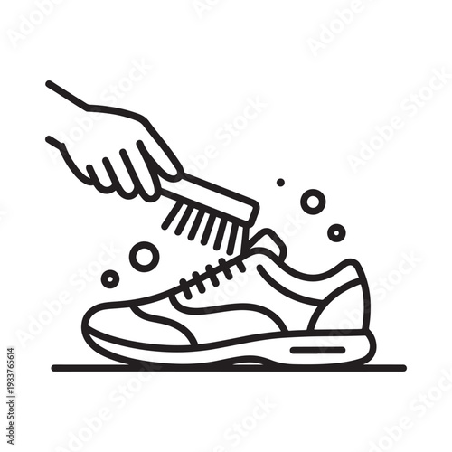 A hand cleaning a sneaker with a small brush and soapy water