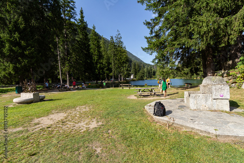 Chamonix-Mont-Blanc, Haute Savoie, France - August 09th, 2025: People enjoying the picnic area at Lake Gaillands in the Les Pelerins neighborhood on a beautiful sunny summer day.