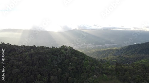 aerial shot, drones flying over a beautiful green mountains and amazing sunny rays over guaduas city in Cundinamarca Colombia 4K