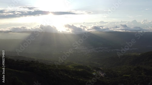 aerial shot, drones flying over a beautiful green mountains and amazing sunny rays over guaduas city in Cundinamarca Colombia 4K