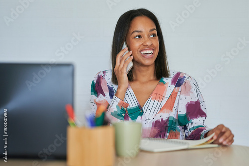 Young entrepreneur managing her business using laptop and smartphone