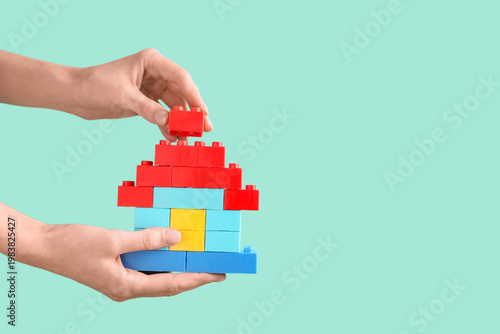 Woman building toy house wi...