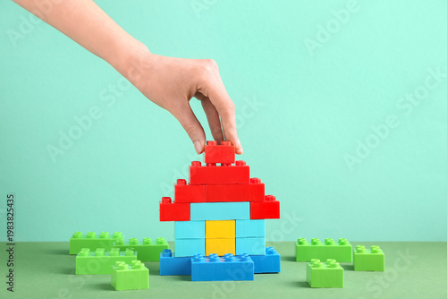 Woman building toy house wi...