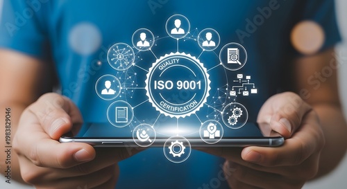 Hands holding tablet with glowing ISO 9001 certification hologram