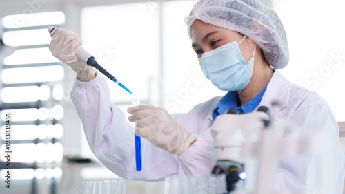 Asian adult scientist conducting chemical research laboratory analysis using micropipette test tube medical experiment biology lab work development