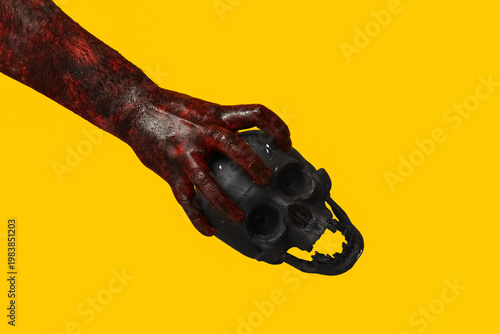 Cuadro en lienzo Hand of zombie with skull on yellow background