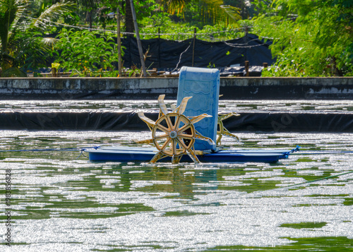 Photography Paddle wheel aerator operating in shrimp farm pond in Indonesia, circulating water and oxygen in aquaculture system