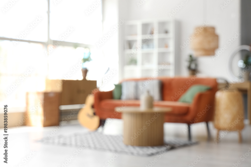 Fototapeta premium Interior of living room with brown sofa, coffee table, acoustic guitar and bicycle, blurred view