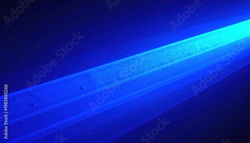 Feixe de luz azul brilhante atravessa um fundo escuro, criando um efeito abstrato e etéreo com gradientes de cor.